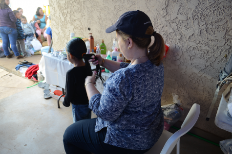 BRAID: Helped by volunteers from Los Angeles and elsewhere, asylum seekers who had been held in detention before being cleared to enter the U.S. were welcomed with their first showers and hot meals at the Casa de Oracion No. 2 church in northern Phoenix Jan. 16. Above, Marian Merritt braided one girl’s hair.