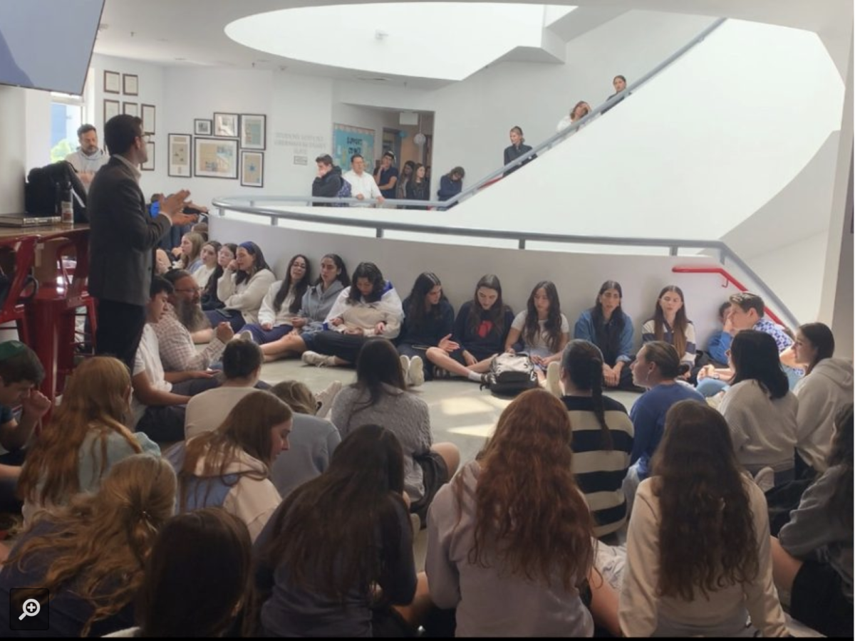 TOGETHER: During Tuesday’s kumzitz, Rabbi Block (standing) told students to find strength in mindfully fulfilling their normal commitments.