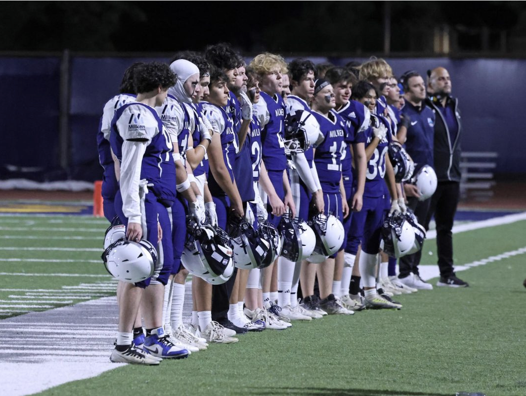 Milken football team and coaches line up for the American and Israeli national anthems at a Milken home game.